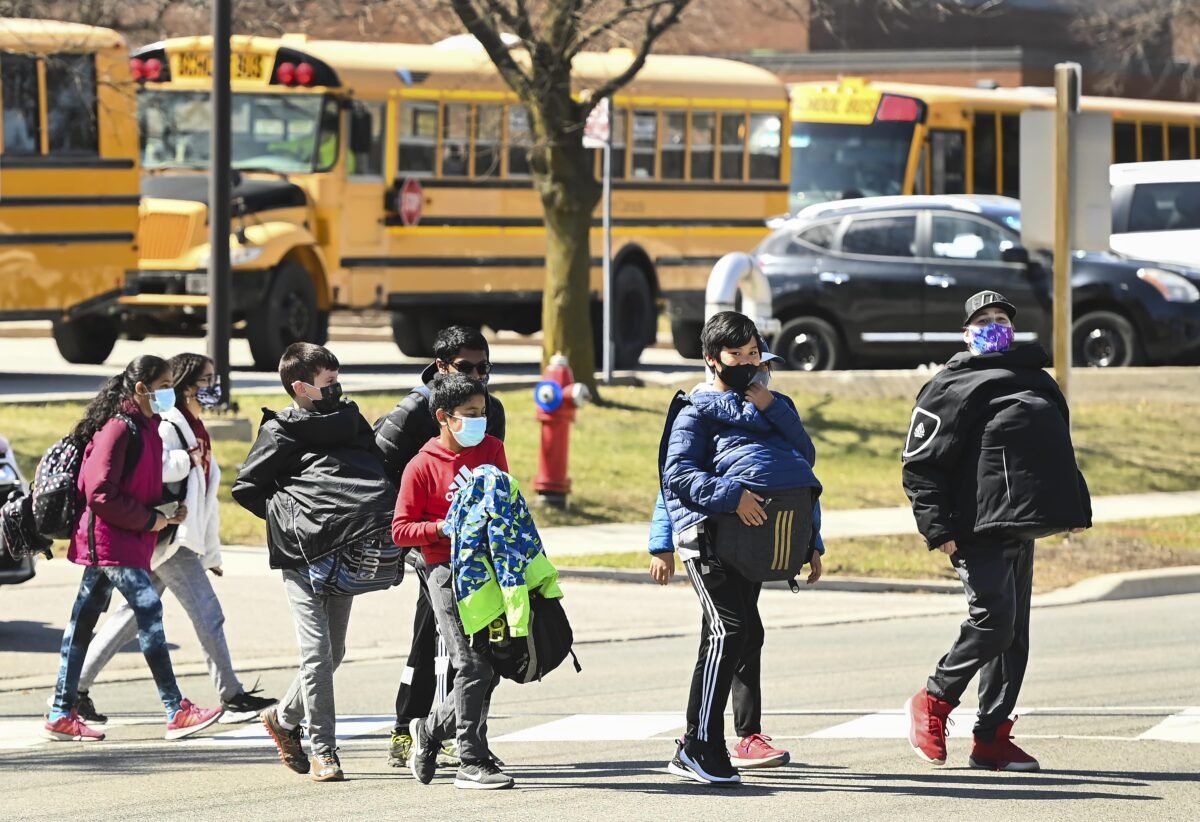 Students cross the street at Tomken Road Middle School in Mississauga, Ont., on April 1, 2021. (Nathan Denette/The Canadian Press)