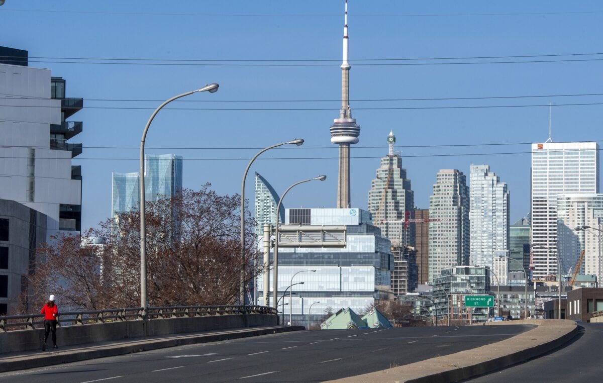 A lone runner on an empty street in Toronto during rush hour on the first working day of the Ontario COVID-19 lockdown, on April 5, 2021. (The Canadian Press/Frank Gunn)