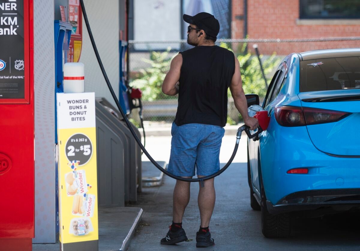 A commuter pumps gas into their vehicle at a Esso gas station in Toronto, Canada, on June 15, 2021. (The Canadian Press/Tijana Martin)