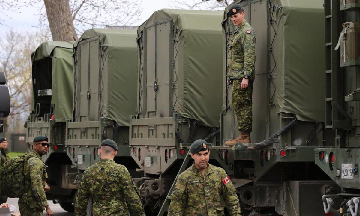 Reservists help pack military vehicles with boats and fuel at CFB Kingston in Kingston, Ont., on May 9, 2017. (Lars Hagberg/The Canadian Press)