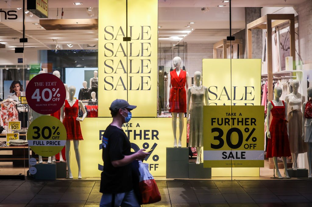 A shopper wearing a mask walks past a shop displaying sales signs during the Boxing Day sales in Sydney, Australia, on Dec. 26, 2020. (David Gray/Getty Images)