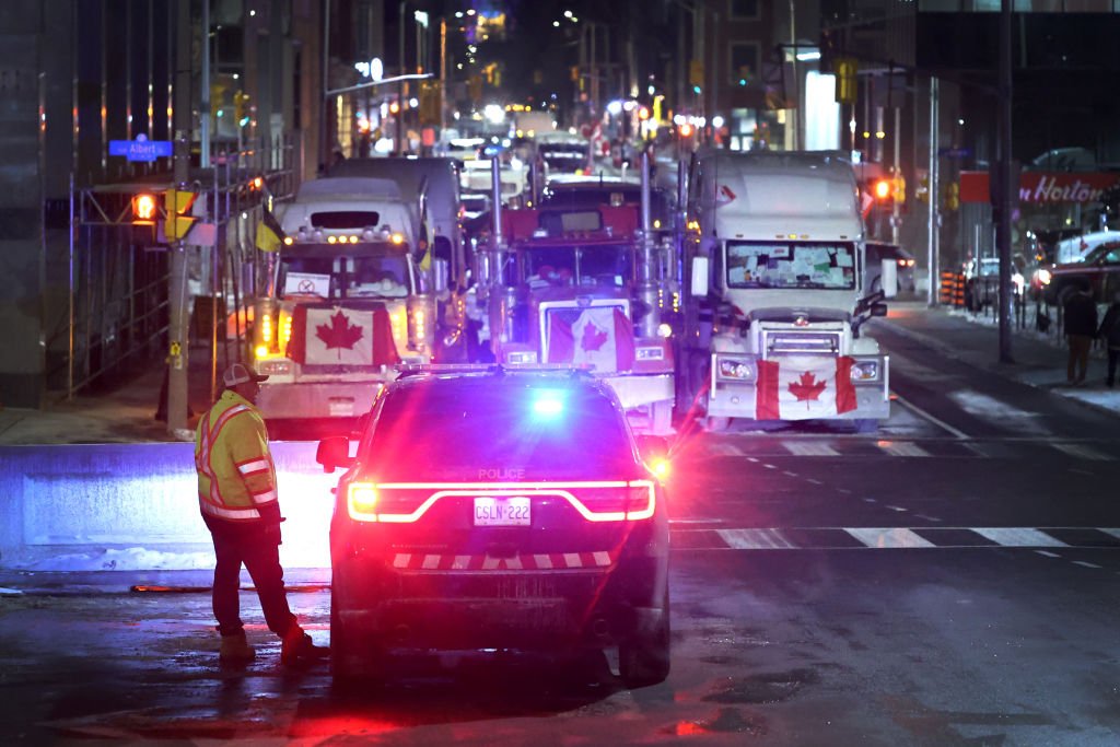 A police vehicle blocks a downtown street to prevent trucks from joining a blockade of truckers protesting vaccine mandates near the Parliament Buildings on February 15, 2022 in Ottawa. (Photo by Scott Olson/Getty Images)