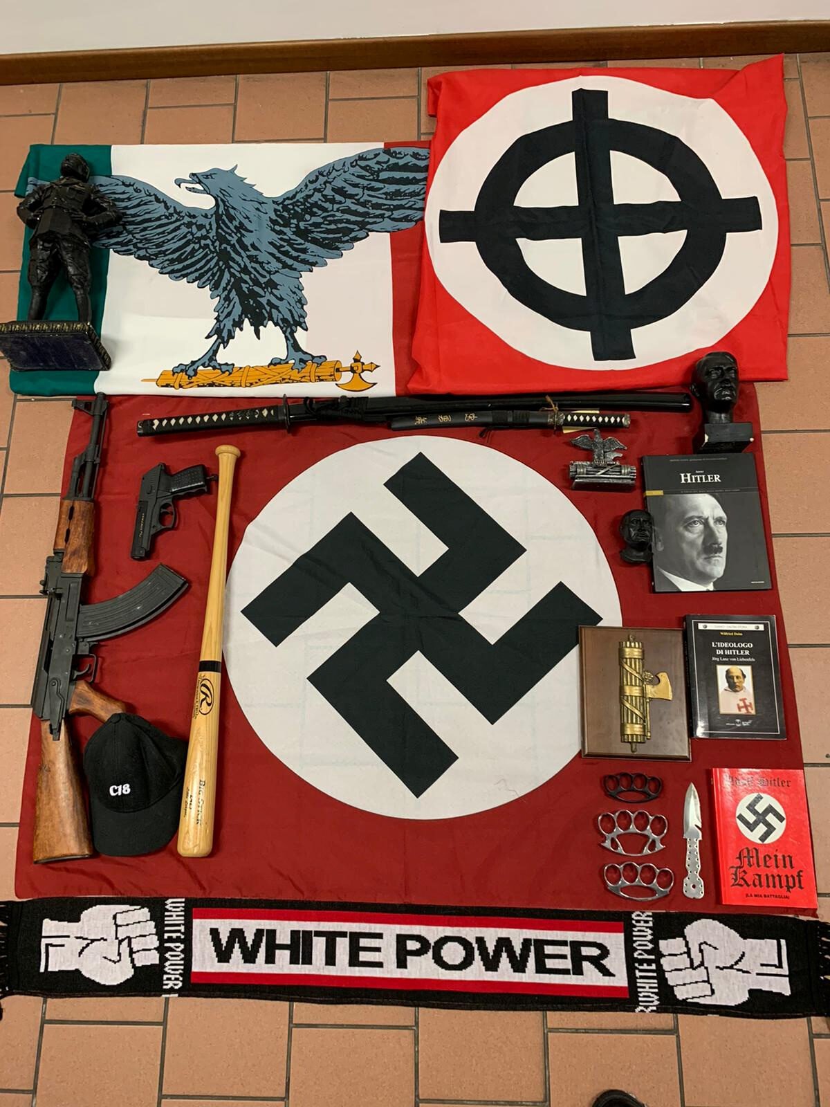 Weapons and a flag with the German Nazi's swastika are displayed by Italian police after they were seized in a raid on a neo-nazi group in Italy, Nov. 28, 2019. (Polizia di Stato/Handout via REUTERS)