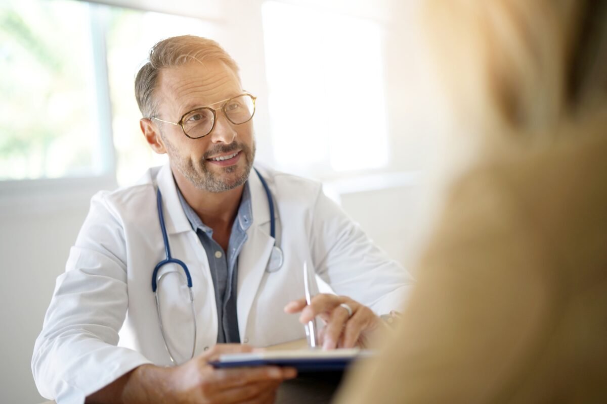 Doctor with patient in medical office (goodluz/Shutterstock)