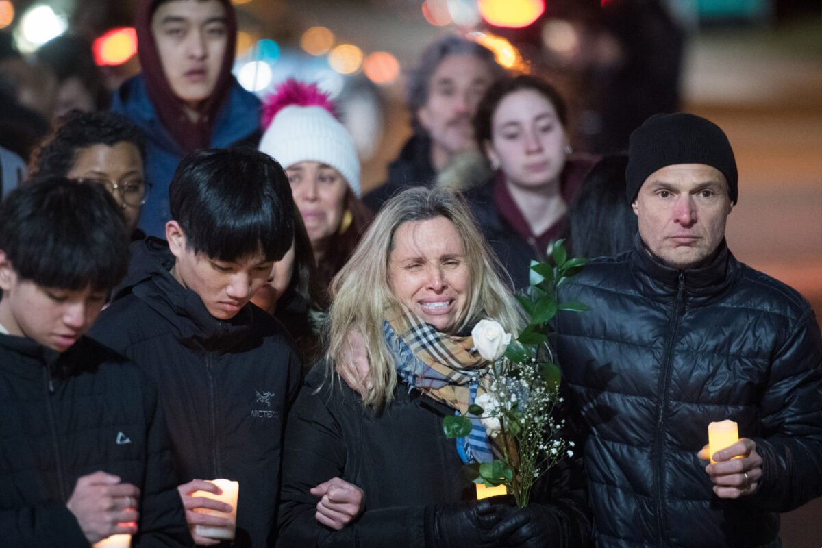 Antonio Magalhaes (R) and his wife, Andrea, take part in a candlelight walk toward Keele Station where their 16-year-old son, Gabriel, was killed in a random attack, in Toronto on March 30, 2023. (Tijana Martin/The Canadian Press)