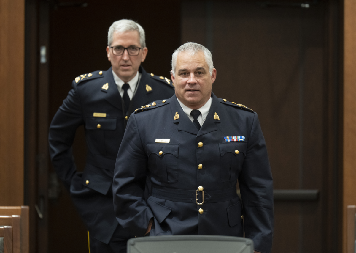 Acting RCMP Commissioner Mike Duheme (R) arrives with Assistant Commissioner Mark Flynn at the Procedure and House Affairs committee in Ottawa on June 13, 2023. (Adrian Wyld/The Canadian Press)