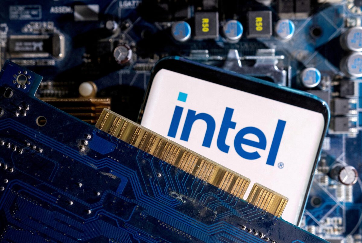 A smartphone with a displayed Intel logo is placed on a computer motherboard on March 6, 2023. (Dado Ruvic/Illustration/Reuters)