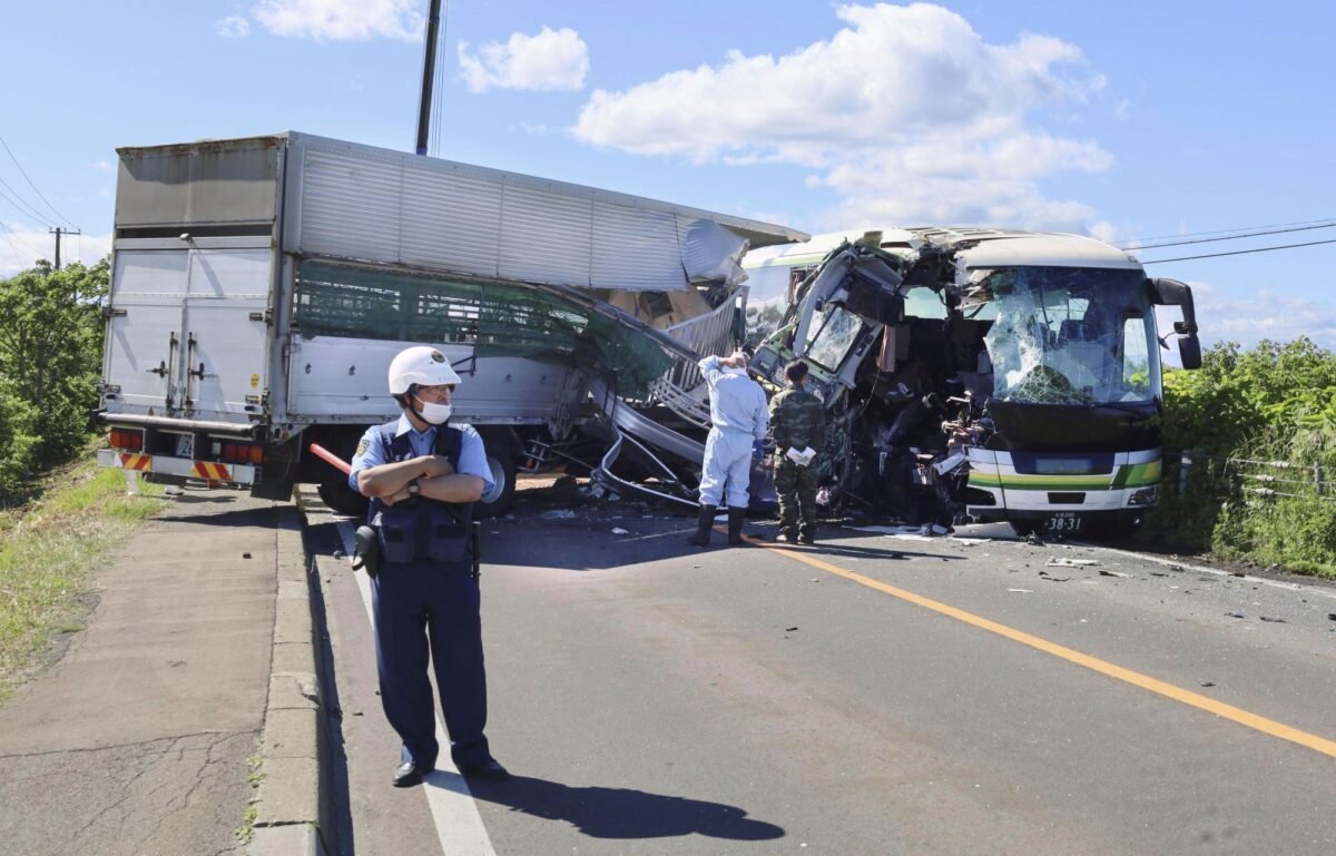 A police stands at the scene of a crash between a bus and a truck in Yakumo, Hokkaido prefecture, northern Japan, on June 18, 2023. (Kyodo News via AP)