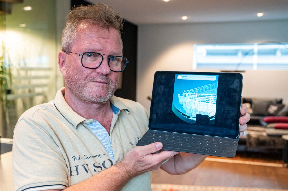 Arthur Loibl, one of the submersible company Oceangate's first customers, holds up a photo of the Titanic, in Straubing, Germany, on June 21, 2023. (Armin Weigel/dpa via AP)