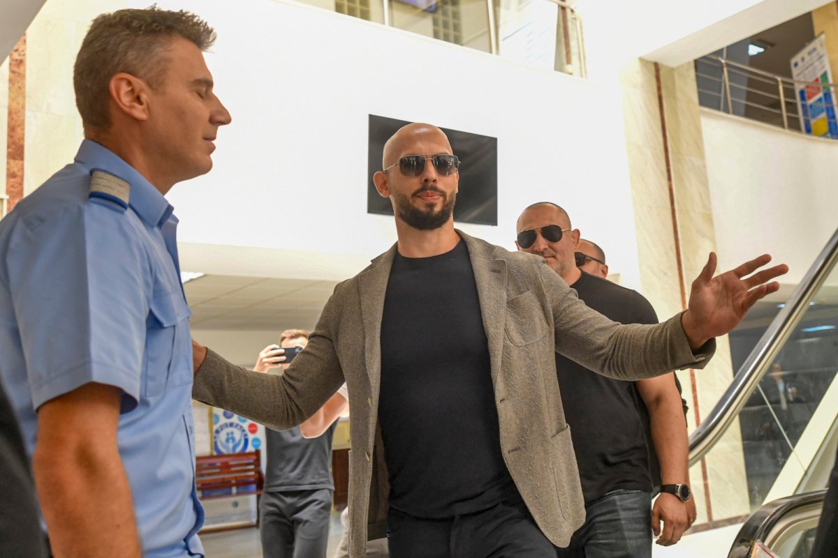 Andrew Tate gestures next to a gendarme as he leaves the Bucharest Tribunal, along with his brother Tristan (R) after the first hearing in their trial in Bucharest, Romania, on June 21, 2023. (Alexandru Dobre/AP Photo)