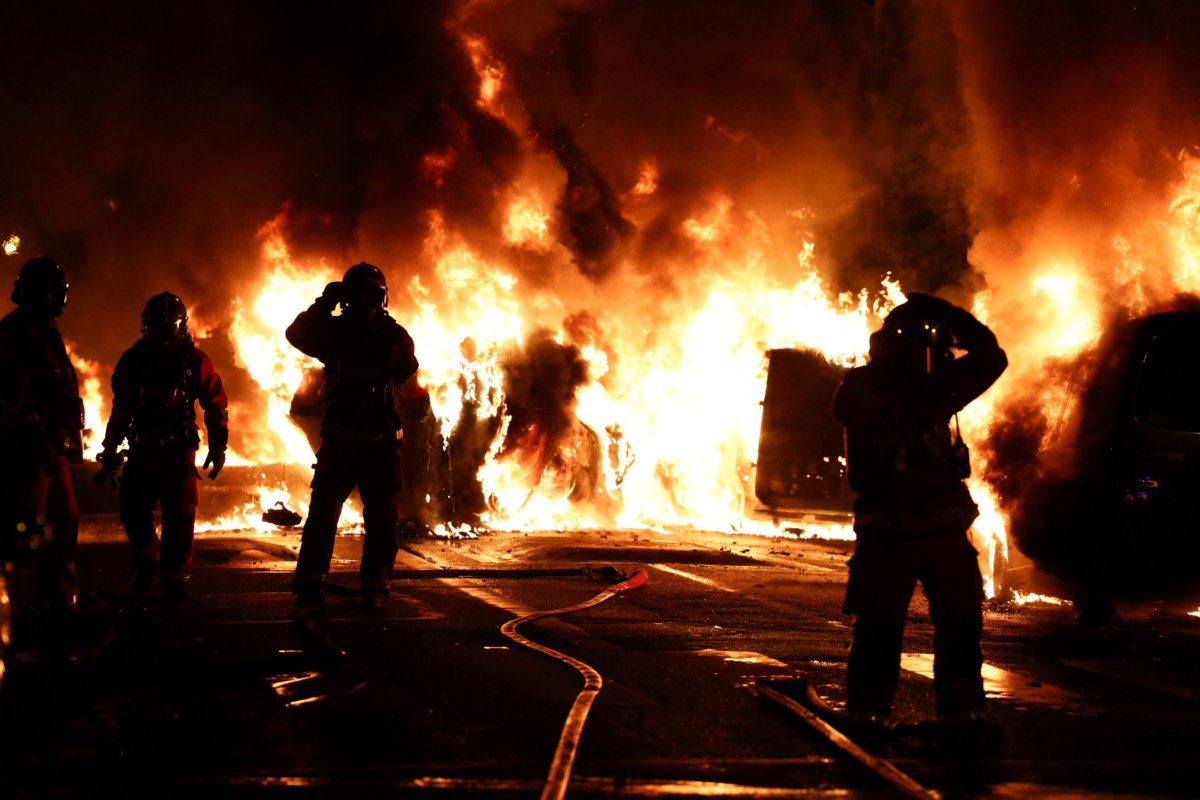 Firefighters stand as they extinguish burning vehicles during clashes between rioters and police, in Nanterre, Paris suburb, France, on June 28, 2023. (Stephanie Lecocq/Reuters)