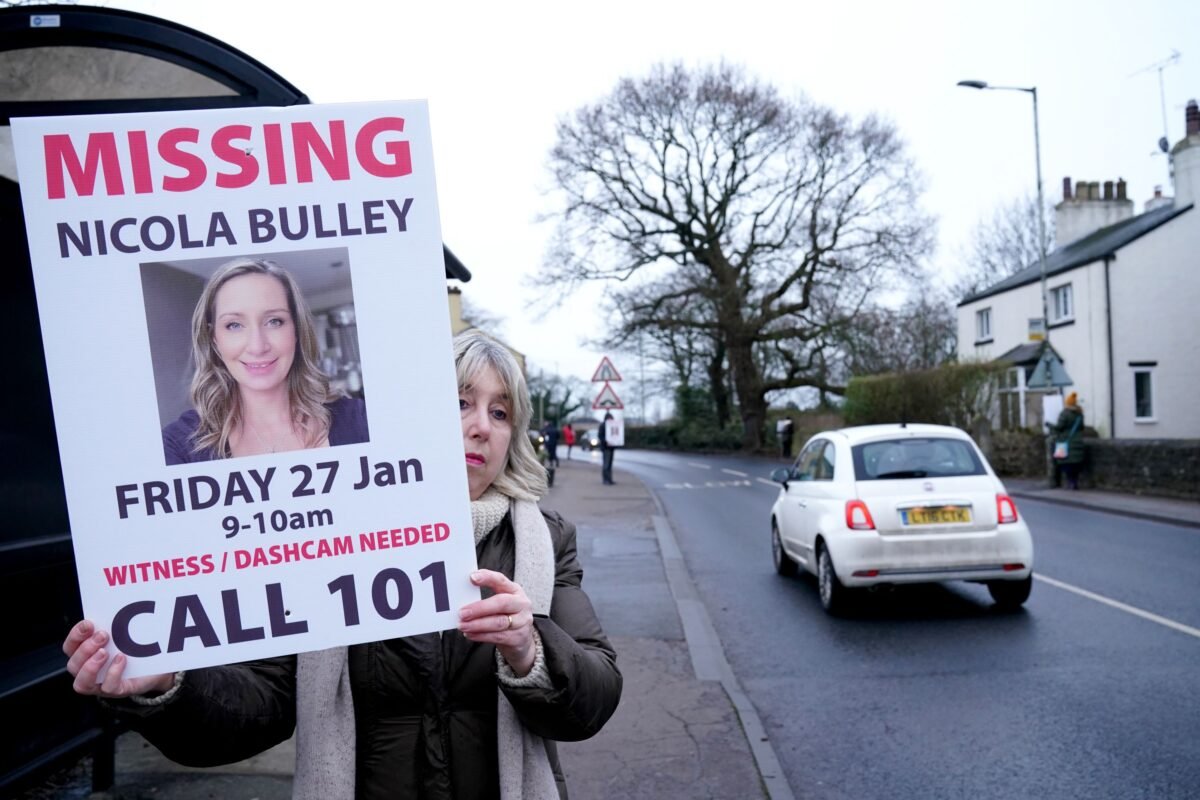 A woman holds up a placard during search for Nicola Bulley, who went missing in Lancashire, England, on Jan. 27, 2023. (PA)