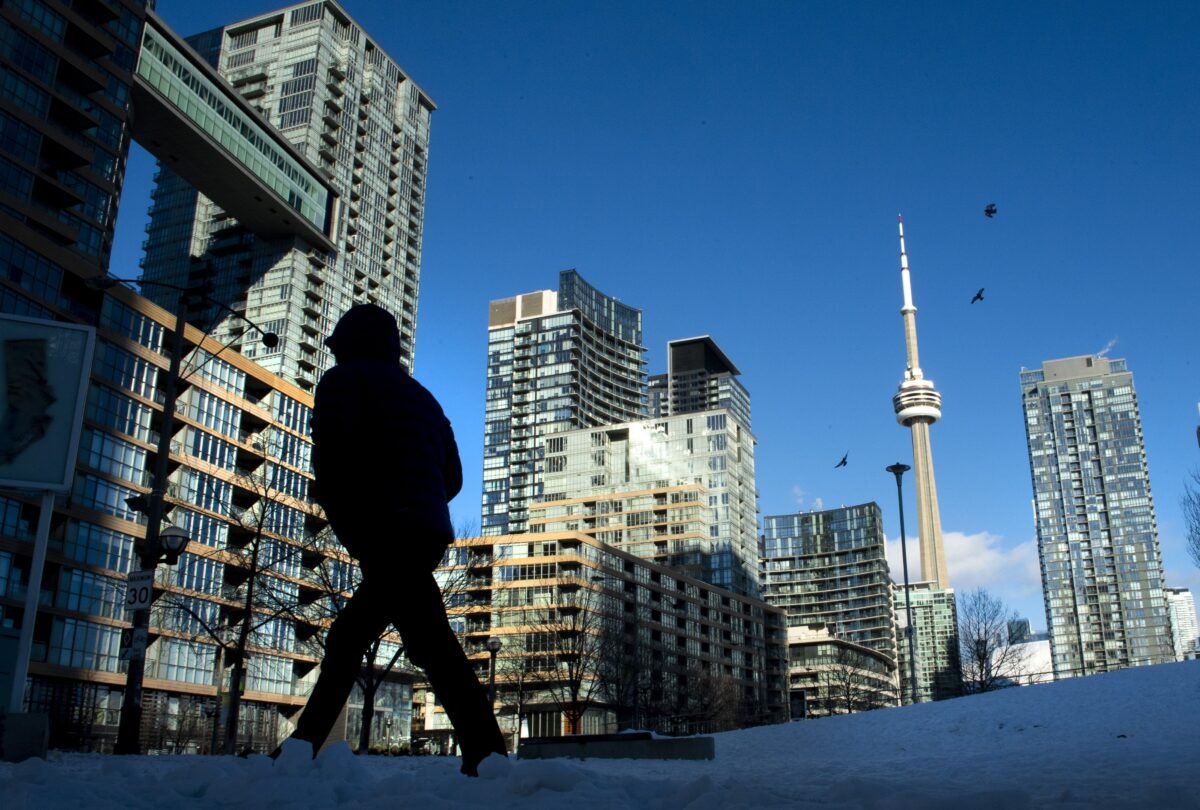 Condo towers dot the Toronto skyline as a pedestrian makes his way through the COVID-19-restricted winter landscape on Jan. 28, 2021. (Frank Gunn/The Canadian Press)
