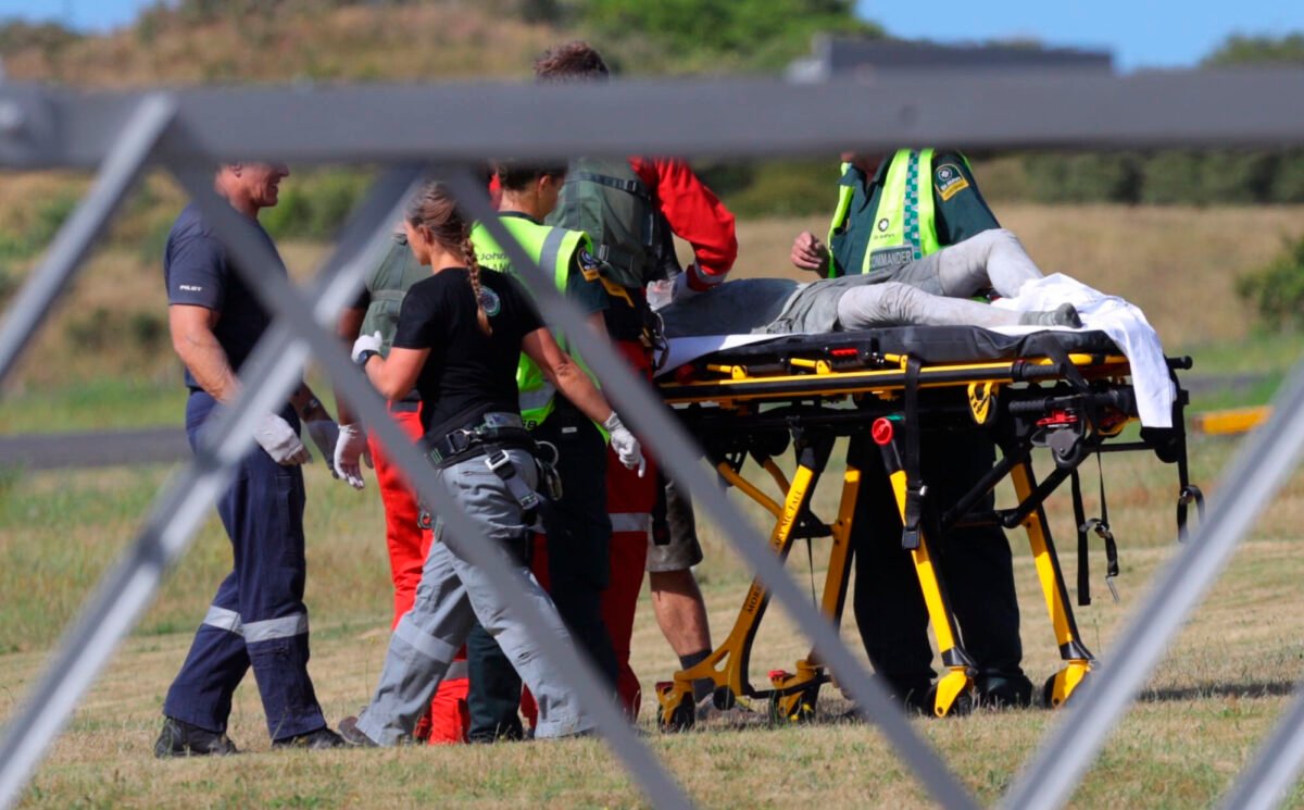 Emergency services attend to an injured person arriving at the Whakatane Airfield after the volcanic eruption on White Island, New Zealand on Monday, Dec. 9, 2019, (Alan Gibson/New Zealand Herald via AP)