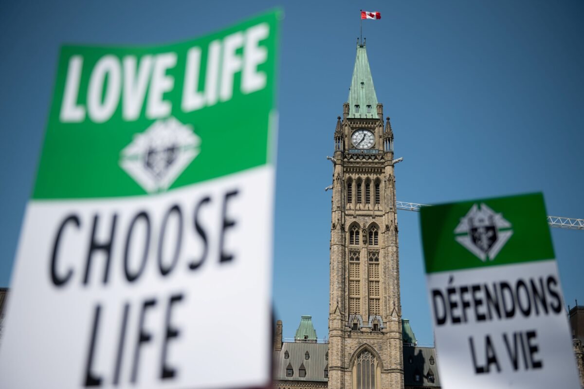 Demonstrators display signs in the March for Life event on Parliament Hill in Ottawa on May 11, 2023. (The Canadian Press/Spencer Colby)