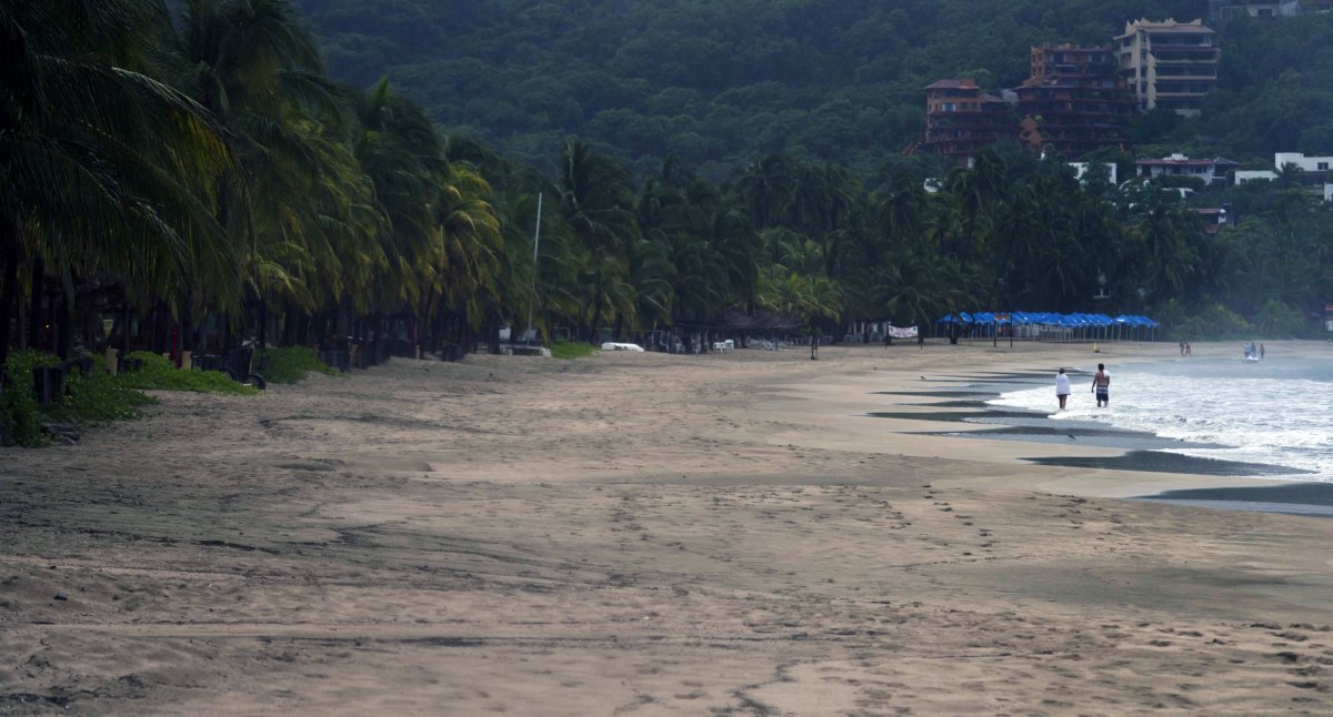 A couple enjoys the beach as hurricane Raymond approaches the shores of Zihuatanejo in the state of Guerrero, Mexico, on Oct. 21, 2013. (Omar Torres/AFP via Getty Images)