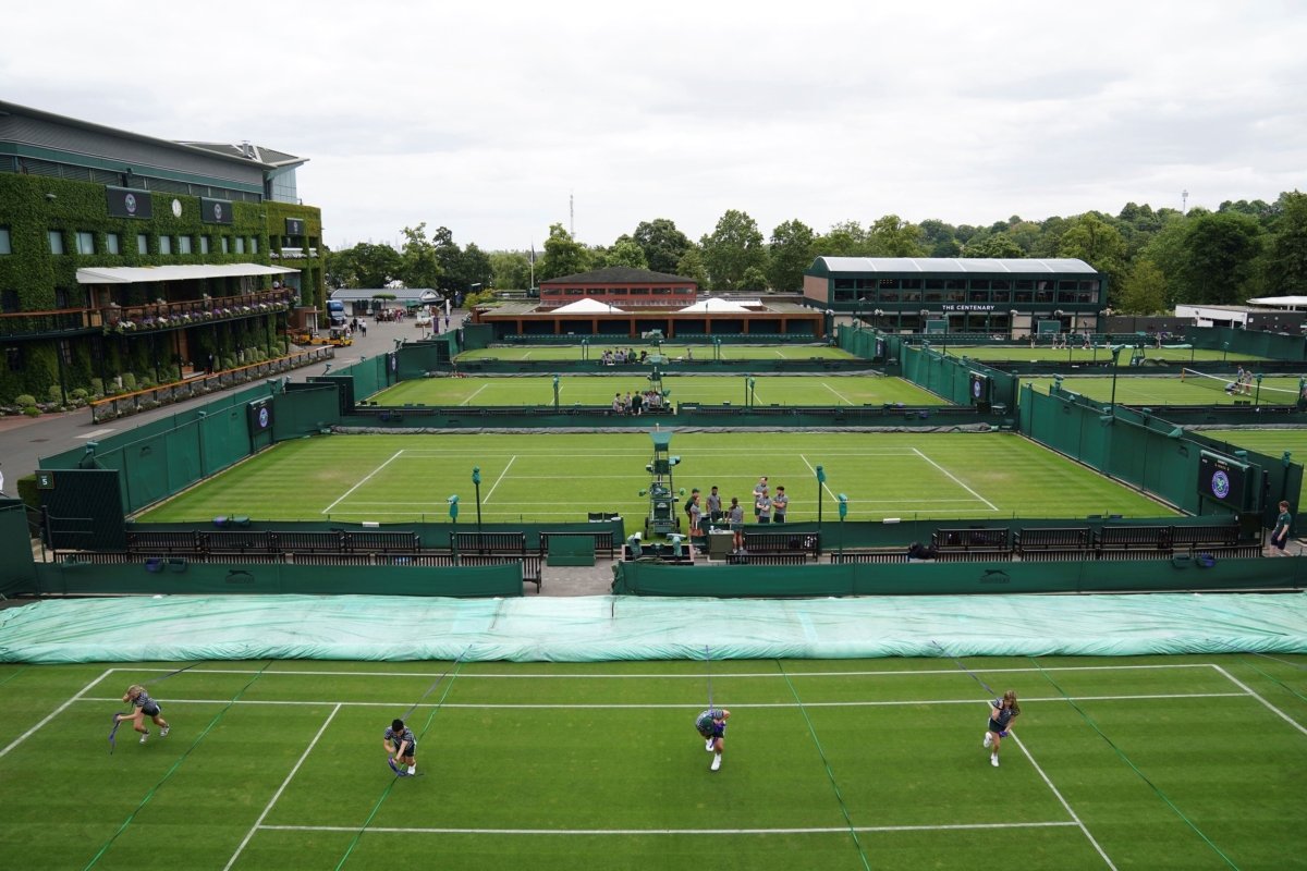 Ground staff practice moving the covers on the outside courts at the All England Lawn Tennis and Croquet Club in Wimbledon, London on July 2, 2023. (John Walton/PA via AP)
