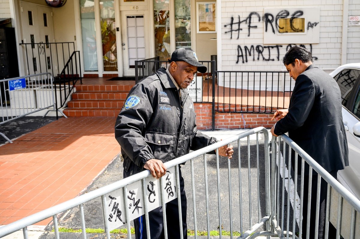A security guard adjusts barricades at the Indian Consulate as broken windows and a graffiti reading "FreeAmritpal" are seen behind, in San Francisco, Calif., on March 20, 2023. (Noah Berger/AFP via Getty Images)