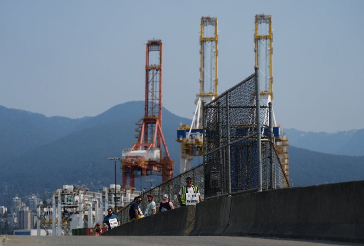 Striking International Longshore and Warehouse Union Canada workers picket at a port entrance in Vancouver, B.C., on July 4, 2023. (The Canadian Press/Darryl Dyck)