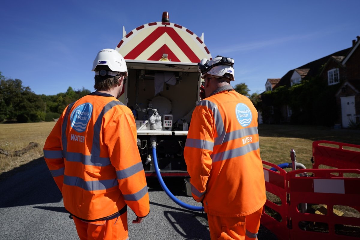A worker from Thames Water delivering a temporary water supply from a tanker to the village of Northend in Oxfordshire, on Aug. 10, 2022. (Andrew Matthews/PA Media)