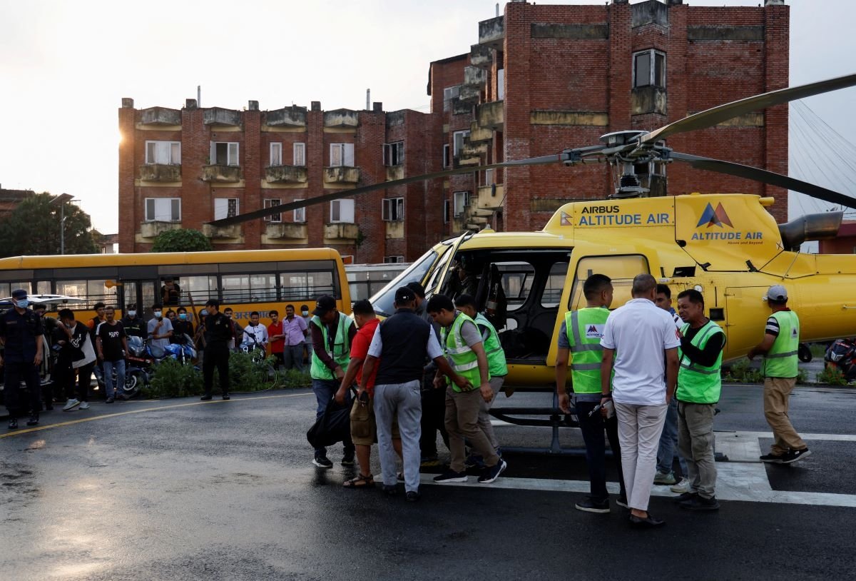 People unload the body from air transport of a person killed in a helicopter crash belonging to Manang air, at Tribhuvan University Teaching Hospital in Kathmandu, Nepal, on July 11, 2023. (Navesh Chitrakar/Reuters)