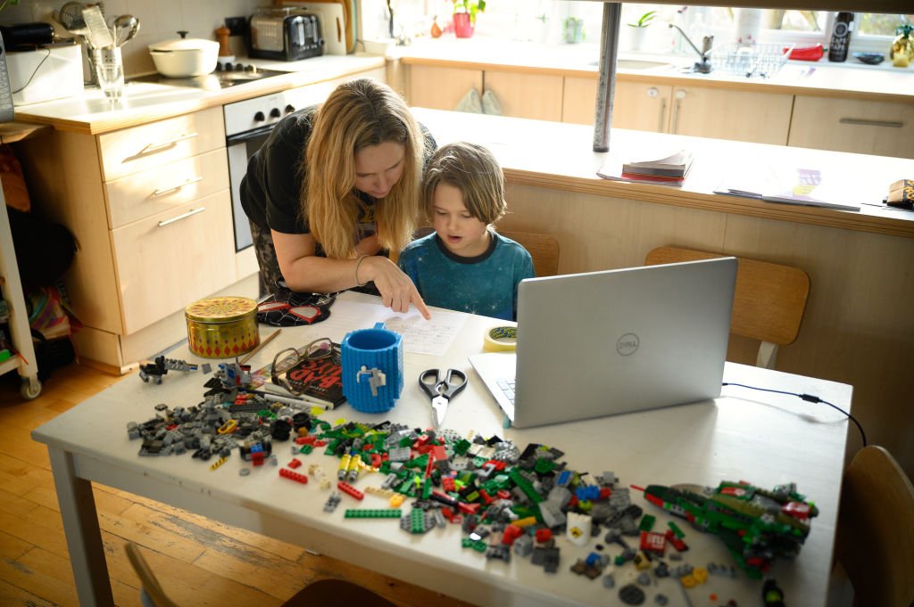 James Laurie, aged 8, is assisted in his online work by his mother Laurette as he continues home schooling  in London, United Kingdom, on Jan. 25, 2021. (Leon Neal/Getty Images)