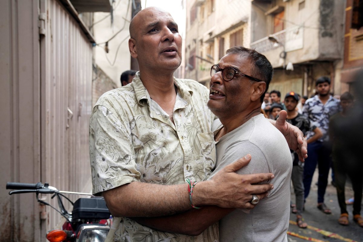 People react on the death of their relatives at the site of a fire incident, in Lahore, Pakistan, on July 12, 2023. (K.M. Chaudary/AP Photo)