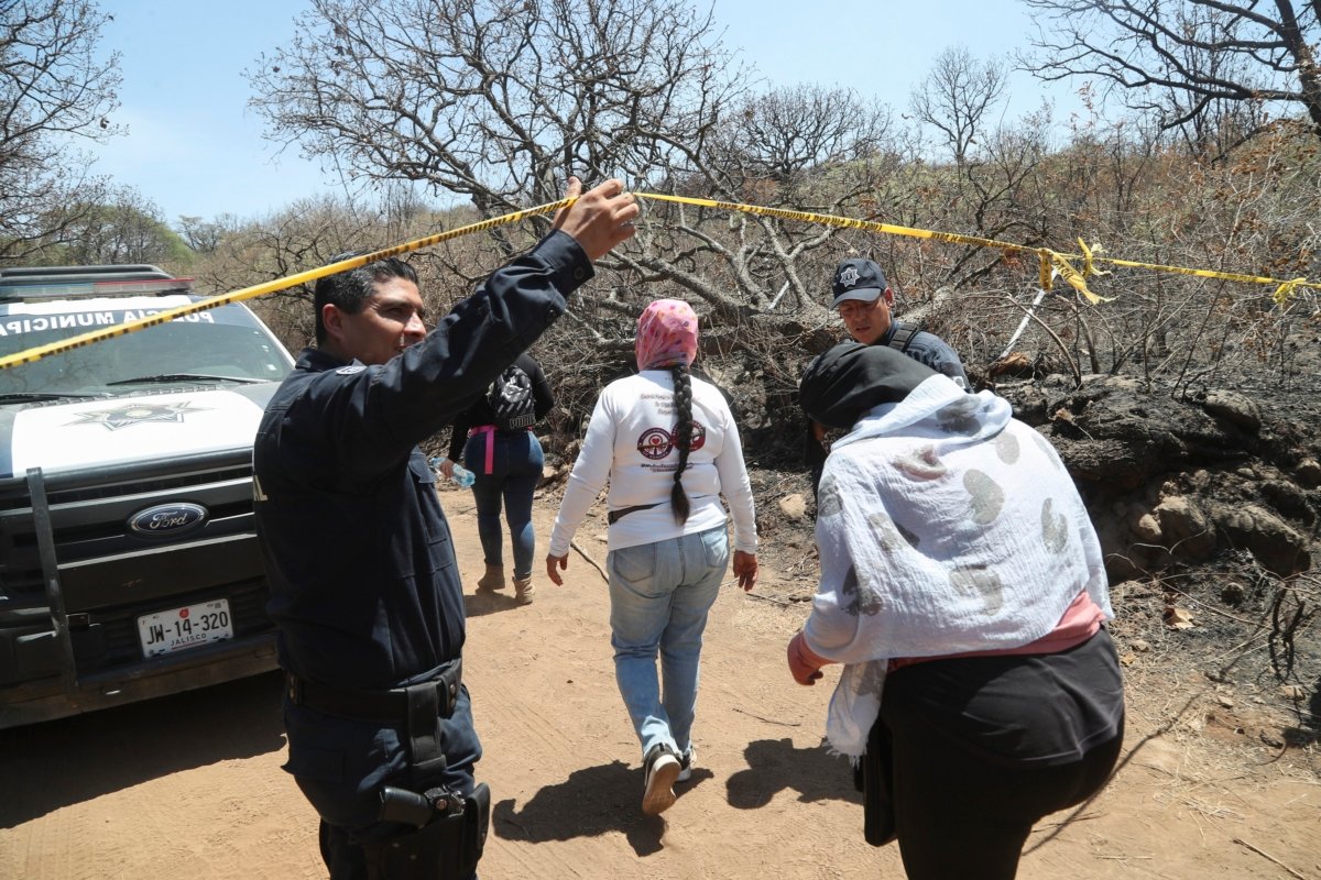 A police officer allows in members of the group Madres Buscadoras de Jalisco who found several sets of human remains after receiving an anonymous tip in Tlajomulco, Jalisco state, Mexico, on June 14, 2023. (Refugio Ruiz/AP Photo)