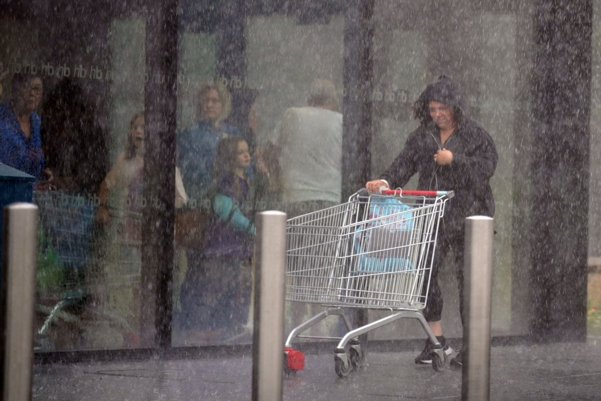 A woman is caught in heavy rain in Speke, Liverpool, England, on July 8, 2023. (Peter Byrne/PA)