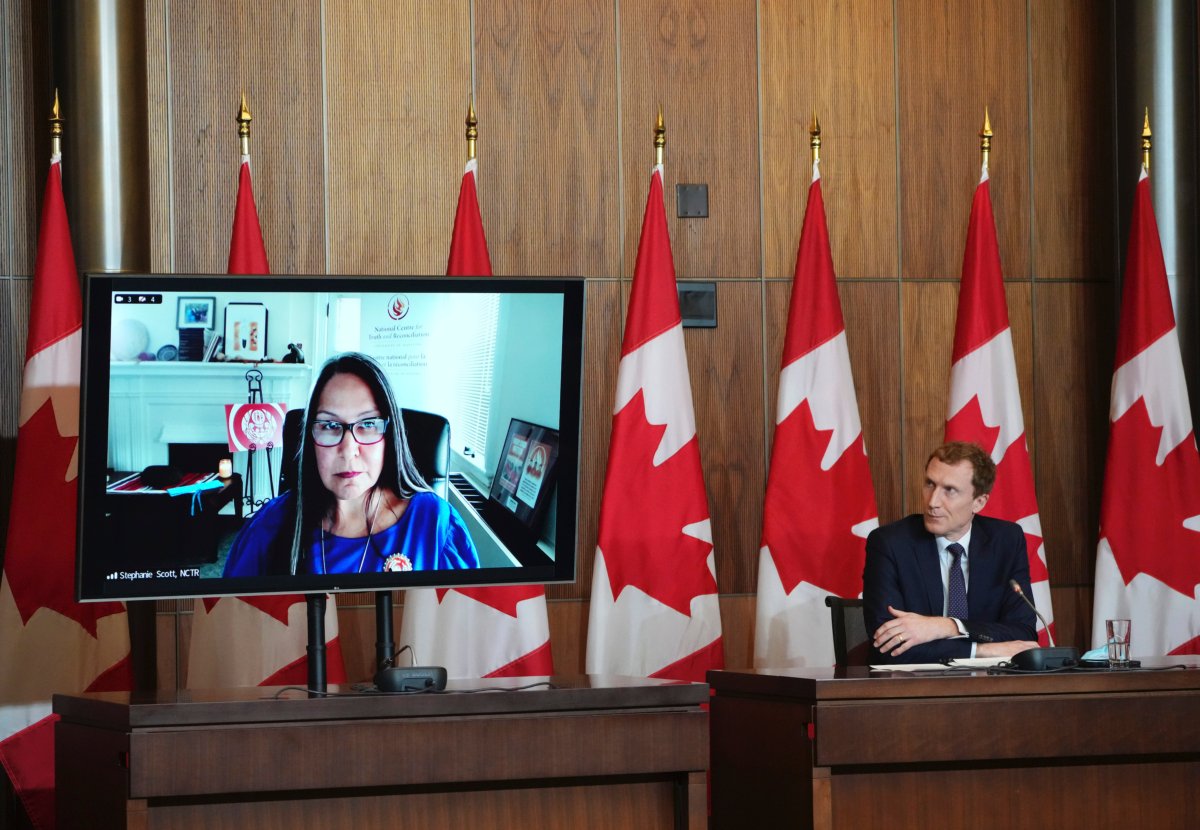 Minister of Crown-Indigenous Relations Marc Miller and Executive Director of the National Centre for Truth and Reconciliation Stephanie Scott (virtually on monitor) listen to a question from media during a press conference in Ottawa on Jan. 20, 2022. (THE CANADIAN PRESS/Sean Kilpatrick)